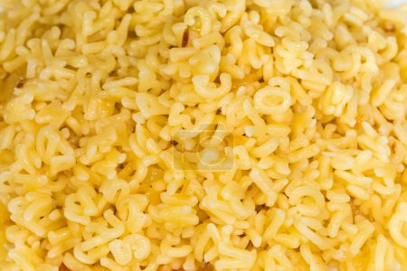 Heap of boiled pasta in shape of the capital letters of English alphabet and Arabic numerals, top view close-up in selective focus