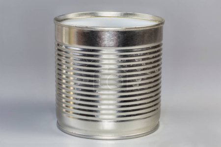 Leere Konservendosen unter einer Konservendose auf grauem Hintergrund öffnen, Seitenansicht Nahaufnahme
