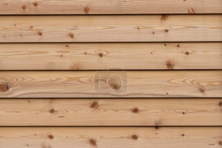 eine schöne horizontale Textur aus braunen Brettern mit Ästen und Harz mit Imprägnierung für Holz ist auf dem Foto zu sehen