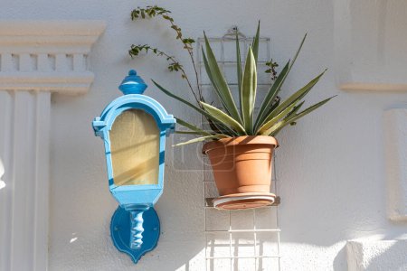 Foto de La luz azul de la calle y la planta de agave en la olla marrón está afuera en la casa blanca en el jardín de verano - Imagen libre de derechos