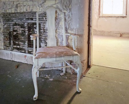 Photo for Vacant vintage chair in a house room in a state of disrepair - Royalty Free Image