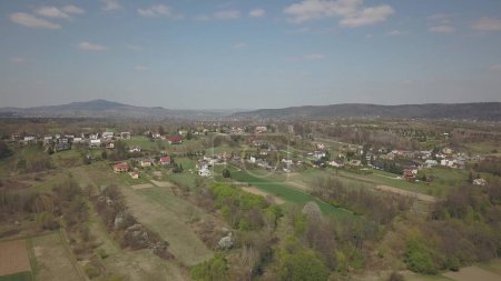 Photo for Panorama from a bird's eye view. Central Europe: The Polish village is located among the green hills and river. Temperate climate. Flight drones or quadrocopter. Urbanization of the landscape. - Royalty Free Image