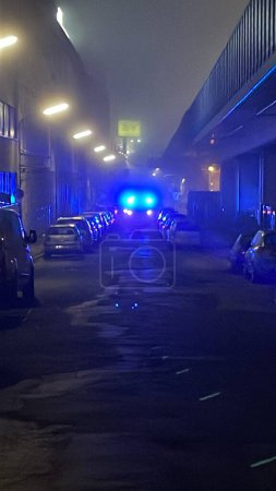 Photo for Vertical blurry shot of ambulance car lights glowwing on the road in the fog at night - Royalty Free Image