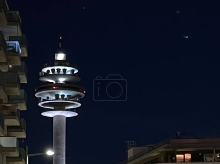 Foto de Futuristic communications tower lit up during night in the city, starry night sky on background, copy space - Imagen libre de derechos