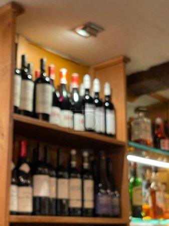 Téléchargez les photos : Blurred shot of various wine bottles on shelves at the restaurant - en image libre de droit
