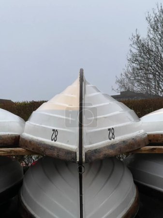 Photo for White boats dry storage outdoors under gloomy grey sky - Royalty Free Image