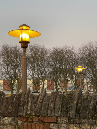 Téléchargez les photos : Old fashioned street lamp lit up with yellow warm light on dusk - en image libre de droit