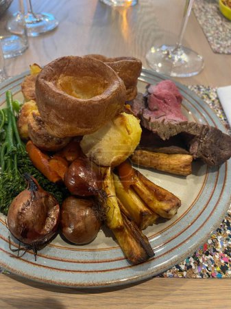 Téléchargez les photos : Delicious baked beef served with Yorkshire pudding vegetables and gravy on traditional English Sunday roast - en image libre de droit