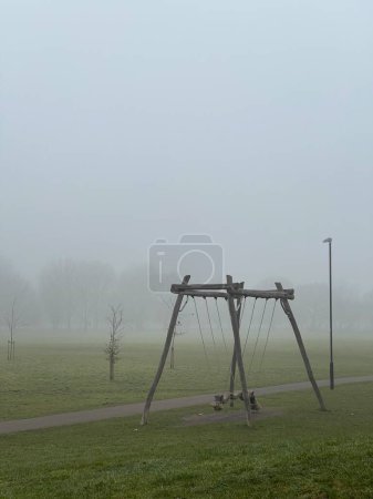 Photo for Wooden swing outdoors in the park on a foggy autumn day - Royalty Free Image