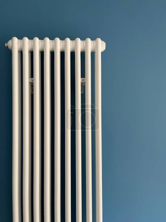 Foto de Radiador de sistema de calefacción vertical blanco en la pared azul - Imagen libre de derechos