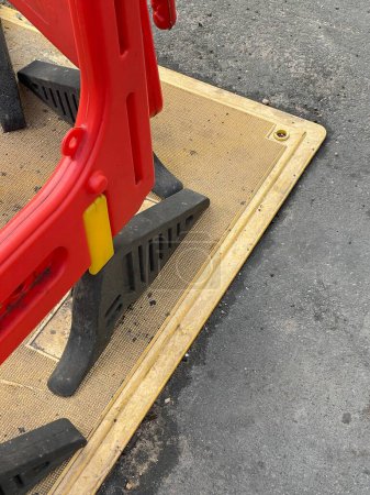 Foto de Tiro recortado de plástico rojo trabajos de mantenimiento barreras viales en hormigón gris - Imagen libre de derechos