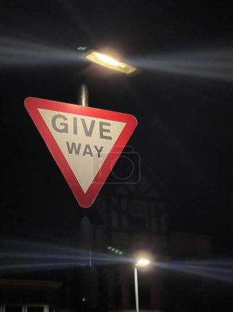 Téléchargez les photos : Céder la place signalisation routière éclairée la nuit - en image libre de droit