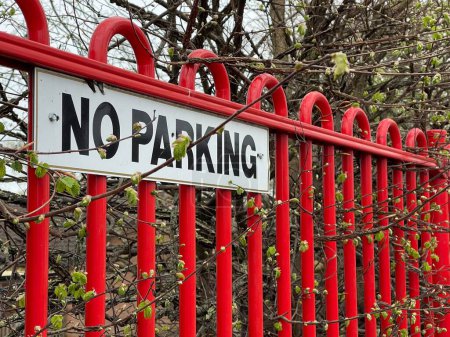 Photo for No parking sign on red metal fence - Royalty Free Image