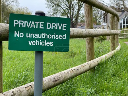 Photo for No unauthorized vehicles sign in front of a wooden fence - Royalty Free Image