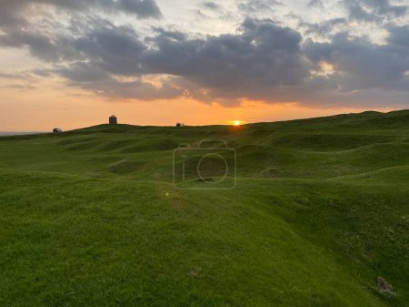 Téléchargez les photos : Coucher de soleil spectaculaire sur des collines verdoyantes - en image libre de droit