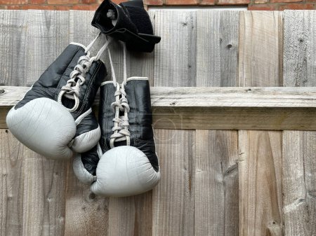 Téléchargez les photos : Gros plan sur les gants de boxe suspendus à une clôture en bois à l'extérieur - en image libre de droit