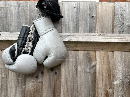Photo for Grey boxing gloves on a wooden fence - Royalty Free Image