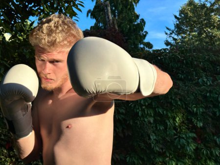 Photo for Handsome shirtless boxer wearing boxing gloves, practicing outdoors - Royalty Free Image