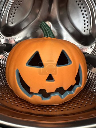 Foto de Tiro vertical de calabaza de halloween jack-o-lantern en lavadora - Imagen libre de derechos