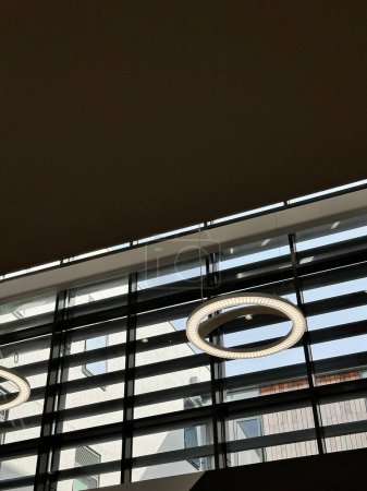 Téléchargez les photos : Plan vertical de l'intérieur minimaliste moderne d'un immeuble de bureaux avec des lampes à led rondes - en image libre de droit