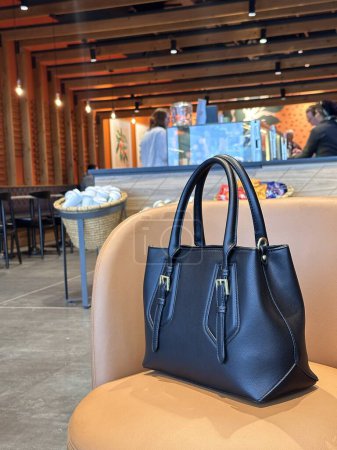 Photo for Black handbag on an armchair at the coffee shop - Royalty Free Image
