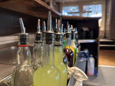 Foto de Botellas con speedpourers en el rack en el bar - Imagen libre de derechos
