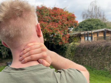 Photo for Cropped rear view close up of a man rubbing his aching neck - Royalty Free Image