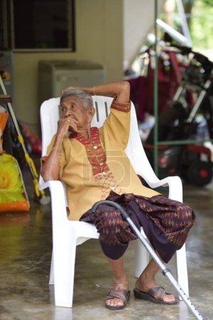Téléchargez les photos : Portrait d'un vieil homme thaïlandais assis sur une chaise - en image libre de droit