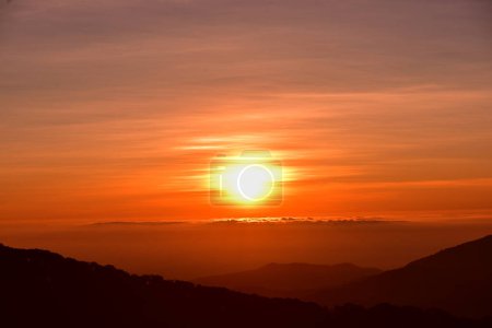 Téléchargez les photos : Beau paysage en montagne au lever du soleil. Ciel orange avec nuages et brume de montagne. - en image libre de droit