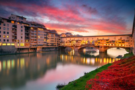 Foto de Florencia, Italia. Imagen del paisaje urbano de la icónica Florencia, Italia con el famoso Ponte Vecchio (Puente Viejo) en el hermoso atardecer de otoño. - Imagen libre de derechos