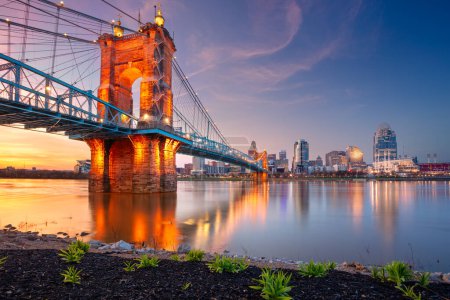 Foto de Cincinnati, Ohio, EE.UU. Imagen del paisaje urbano de Cincinnati, Ohio, EE.UU. skyline céntrico con el puente colgante John A. Roebling y reflejo de la ciudad en el río Ohio al atardecer de primavera. - Imagen libre de derechos