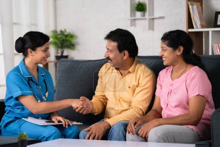 Photo for Happy indian nurse greeting by shaking hands with middle aged couples during home visit at home - concept of medical support, Homecare Service and Health Assessment - Royalty Free Image