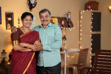 Téléchargez les photos : Happy souriant couples âgés indiens en toute confiance debout en regardant la caméra à la maison au festival diwali concept de liens familiaux, camaraderie et mode de vie à la retraite - en image libre de droit