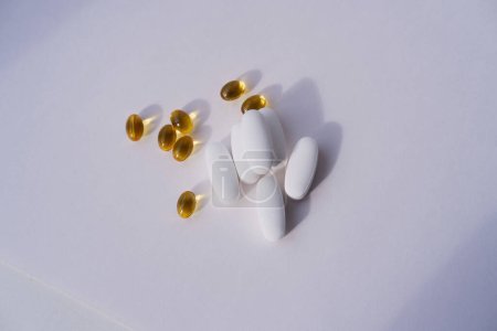 Vitamin-D-Kapseln und Magnesiumcitrat-Tabletten in Großaufnahme auf weißem Hintergrund. Nahrungsergänzungsmittel