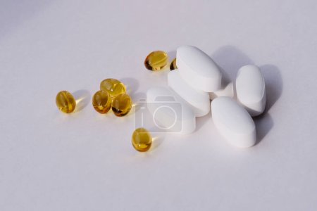 Vitamin-D-Kapseln und Magnesiumcitrat-Tabletten in Großaufnahme auf weißem Hintergrund. Nahrungsergänzungsmittel