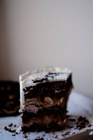 beau gâteau au chocolat avec cacahuètes et crème tendre beurre gros plan. délicieux gâteau au bento sucré. morceau de gâteau sur fond blanc
