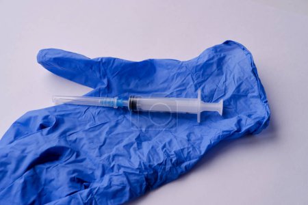 blue medical glove and medical syringe close-up