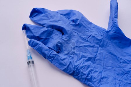 Gant médical bleu et seringue médicale en gros plan