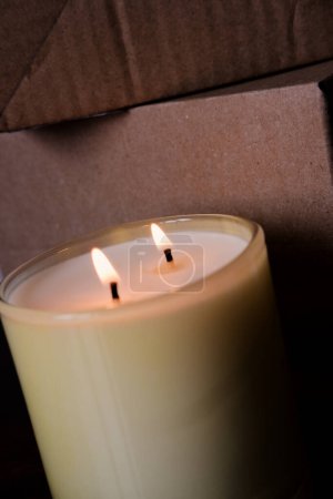large glass jar with natural candles. burning soy wax candle close up.