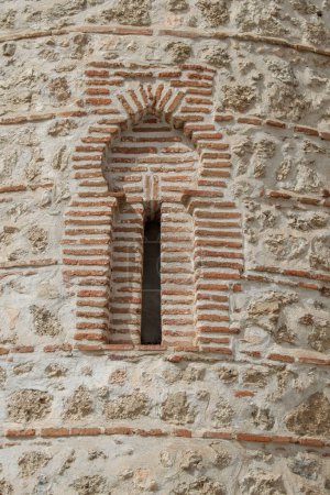 Téléchargez les photos : Étroite fenêtre en fer à cheval en brique et pierre sur la façade d'une chapelle à Madrid. Espagne - en image libre de droit