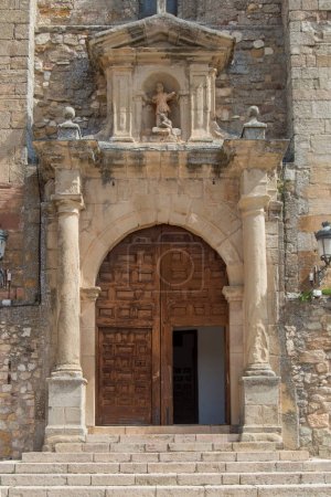 Photo for Wooden door with arch, columns and stone sculpture in the church of san Juan Bautista in Atienza, province of Guadalajara. Spain - Royalty Free Image