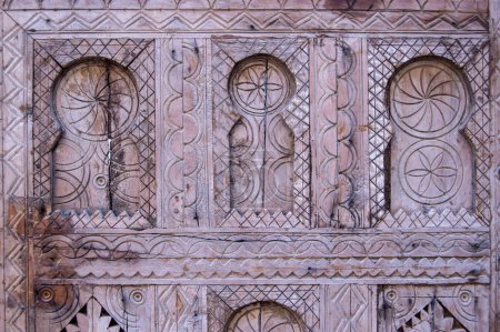 background with carved wood forming geometric elements and horseshoe arches