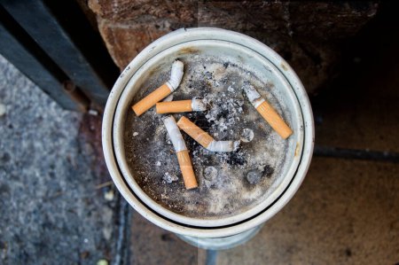 El resto de cigarrillos en el cenicero en una calle vista desde arriba