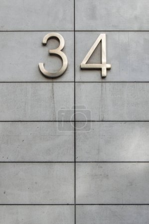 Metallzahl vierunddreißig in einer Fassade, die horizontal in Rechtecke unterteilt ist