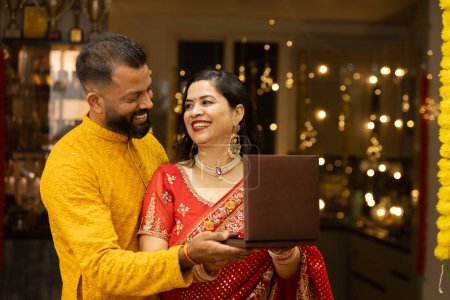 Junger indischer Ehemann schenkt seiner Frau wertvollen Schmuck zum Diwali oder Hochzeitstag. Mann und Frau in traditioneller Tracht anlässlich des Festes.