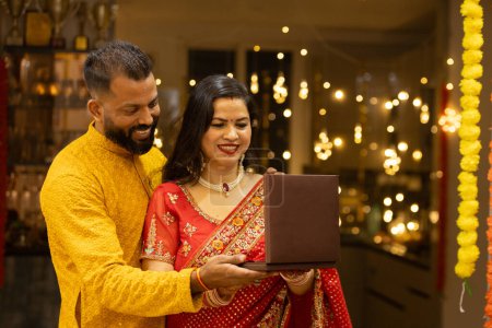 Junger indischer Ehemann schenkt seiner Frau wertvollen Schmuck zum Diwali oder Hochzeitstag. Mann und Frau in traditioneller Tracht anlässlich des Festes.