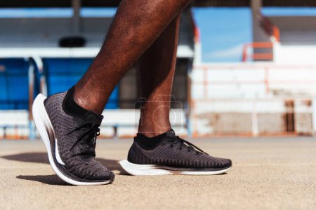 Foto de Joven atleta asiático corredor deportivo negro hombre usar los pies activos listos para correr entrenamiento al aire libre en el camino de la cinta de correr para un paso adelante, entrenamiento de ejercicio saludable, zapato de espalda de primer plano - Imagen libre de derechos