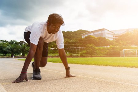 Foto de Asiático joven atleta deporte corredor negro hombre usar pies zapato activo listo para comenzar a correr el entrenamiento al aire libre en la cinta de correr para un paso adelante, ejercicio saludable, primer plano frente a la cara - Imagen libre de derechos