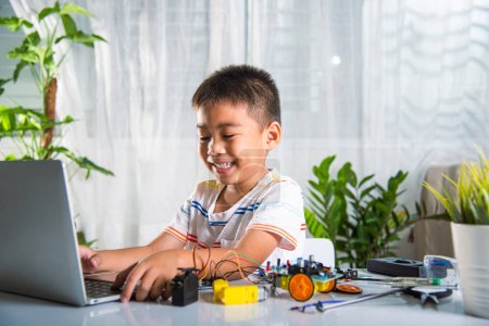 Téléchargez les photos : Enfant asiatique garçon apprend le codage et la programmation avec ordinateur portable pour voiture robot Arduino, Petits enfants élèves dactylographier le code dans l'ordinateur avec jouet de voiture, STEAM éducation AI technologie cours école apprentissage - en image libre de droit