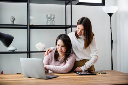 Photo for Asian mother and teenage daughter looking at laptop computer at home office, happy family work together, middle age woman and teen they shoping online on computer - Royalty Free Image